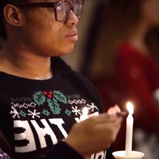 Illuminated by handheld candles, 两名女TCU学生在TCU教堂聆听圣诞礼拜.